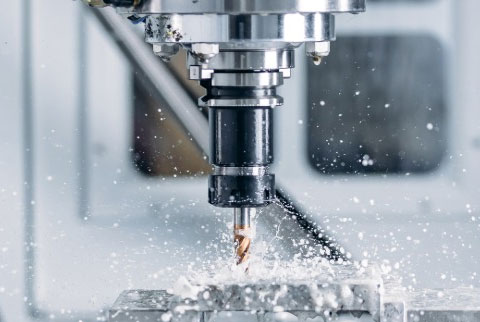 AK Machining specialist cleaning a machined part